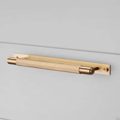 Tirador para mueble alargado con placa en cruz de latón 125